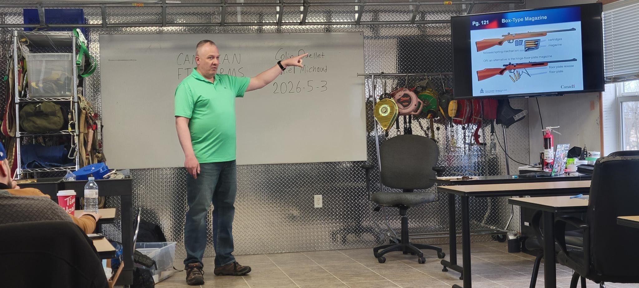 Instructor pointing at whiteboard during firearms safety course